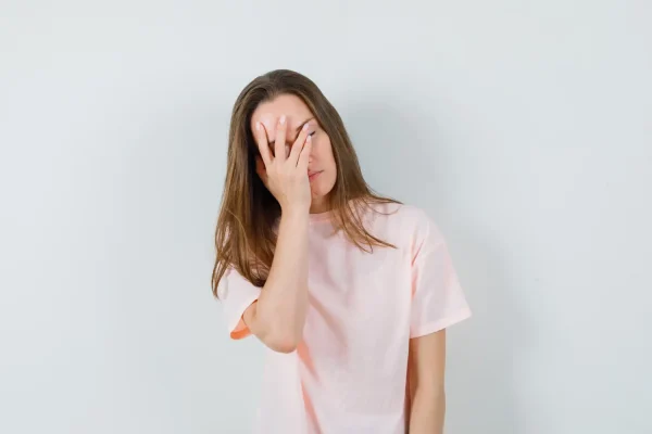 Woman covering her face after experiencing puckering of face during PDO thread lift recovery