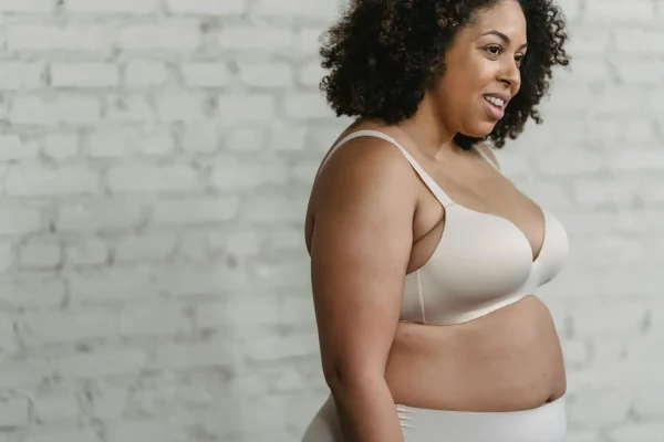 Woman in underwear and is slowly seeing her tummy tuck results