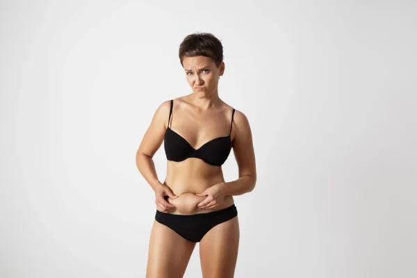Woman wearing black underwear and wondering if she makes a good liposuction candidate