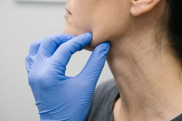 Clinician checking skin recoil along the jawline to assess thread lift candidacy