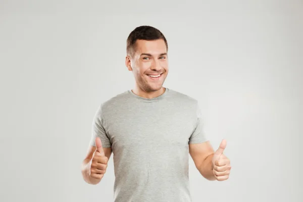 Man putting two thumbs up after successfully recovering from a plastic surgery