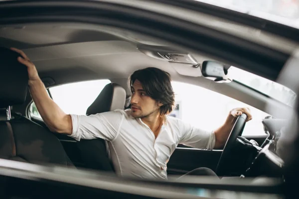 Man wearing white polo and able to drive again after neck lipo recovery
