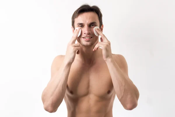 Man wiping cotton pads on his face for skincare after Botox injection