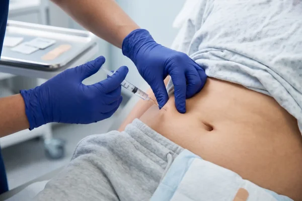 Provider administering a subcutaneous tesamorelin injection at a clinic
