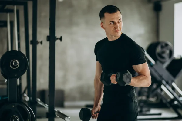A man lifting dumbbells in a gym, representing strenuous exercise