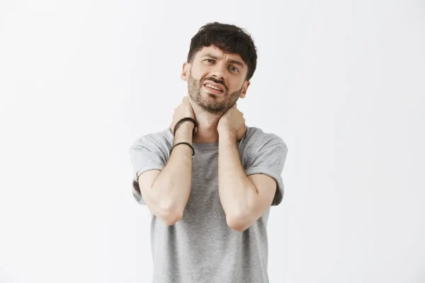 A man winces and holds his neck in discomfort, illustrating the targeted area of concern that differentiates a specific neck contouring procedure