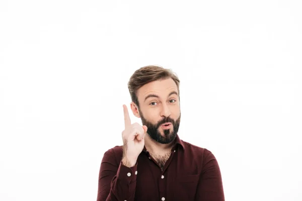 A portrait of a bearded man with brown hair, wearing a button-down, maroon shirt