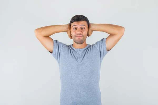 A relaxed young man with his hands placed behind his head, naturally framing and exposing his chin and neck area