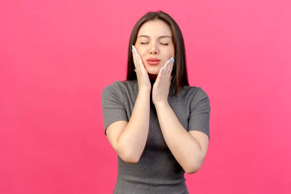 A woman gently touching her face and neck