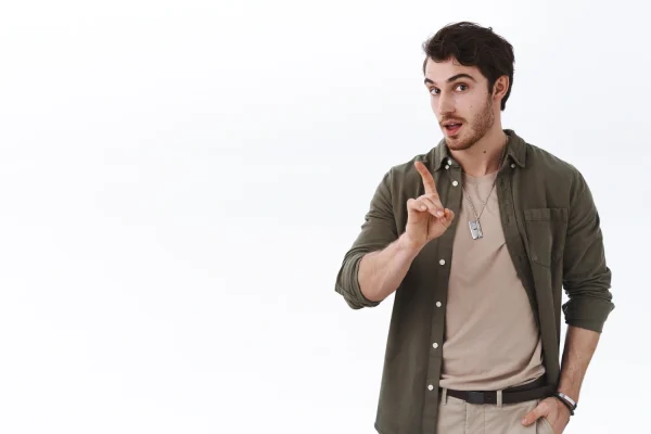 A young man raising his index finger with an eager expression
