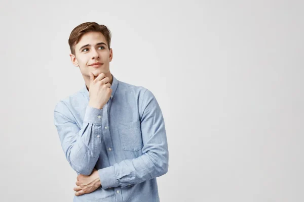 A young man with a tight, well-defined jawline and smooth neck looks upward thoughtfully