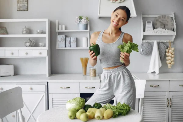 Fit woman holding fresh vegetables in kitchen to maintain healthy lifestyle for longer-lasting filler results