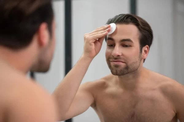 Man applying gentle skincare product to forehead area as part of post-Botox aftercare routine