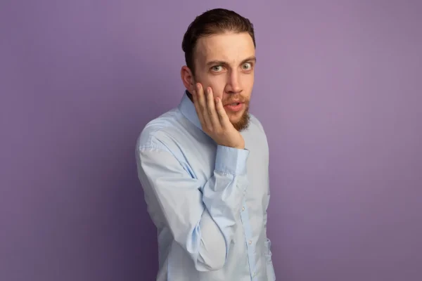 Man holding his cheek and jaw area demonstrating FaceTite treatment zones on the face