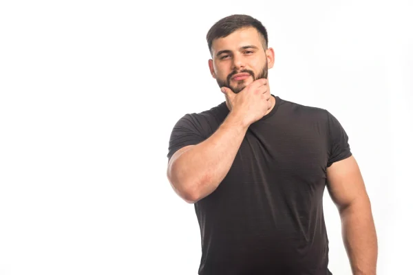 Man touching his chin and jawline while considering chin liposuction procedure