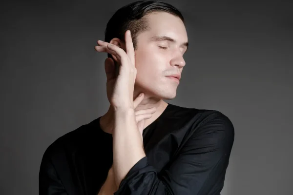 Man touching his jawline and neck area examining signs of aging that PDO threads