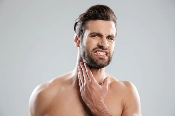 Man touching his neck and examining loose skin concerns, illustrating the need for neck tightening treatments