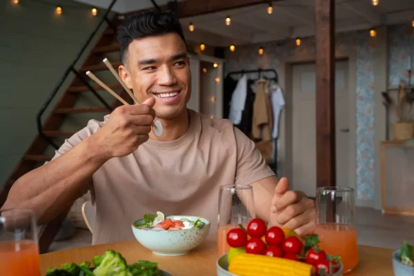 Smiling man enjoying a healthy meal with fresh vegetables, illustrating natural eating habits