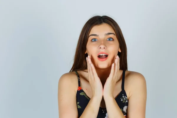 Woman framing her lower face and jawline with hands highlighting FaceTite treatment areas for skin tightening