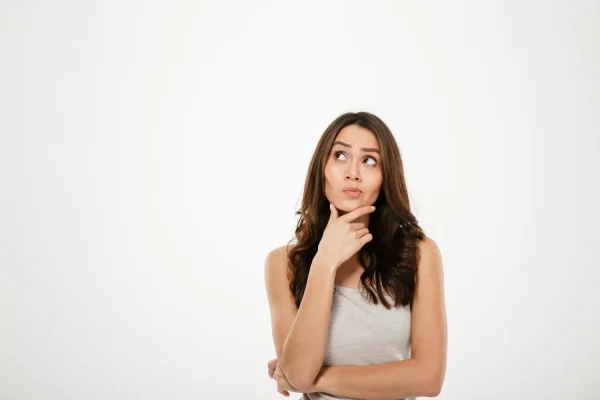 Woman thinking about how long jawline fillers last while touching her chin