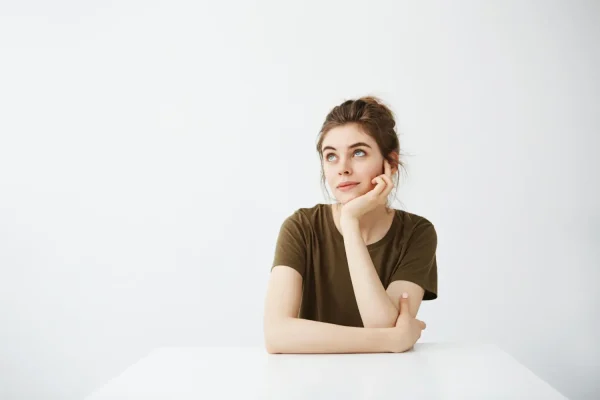 Woman thoughtfully considering FaceTite as a minimally invasive option for facial skin tightening after weight loss