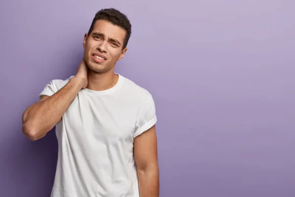 Young man holding his neck showing concern about submental fat that neck lipo can address