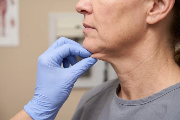 Clinician assessing neck skin elasticity to check facial contouring candidacy in Tampa
