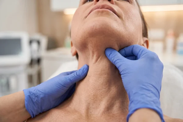 Clinician checking loose neck skin before non-surgical tightening