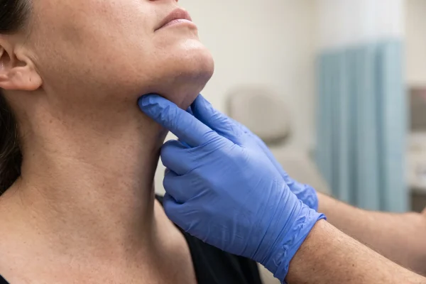 Clinician palpating tissue under the chin to check for firmness after radiofrequency skin tightening
