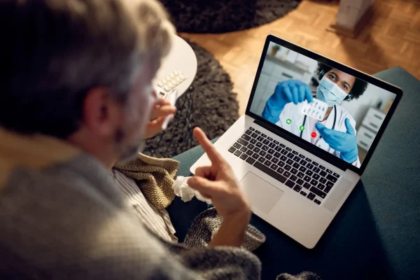 Closeup of man having video call with his doctor in the evening at home