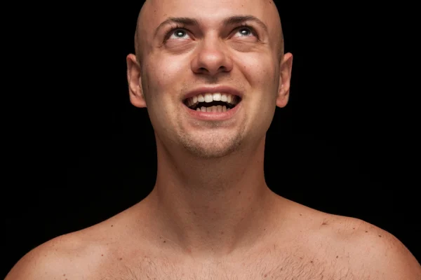 miling man tilting head back to show neck and jawline area where Botox targets platysma muscles for double chin reductionmiling man tilting head back to show neck and jawline area
