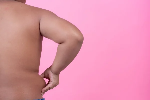 Obese boy who is overweight on a pink background
