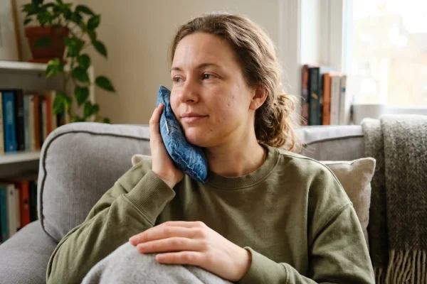 Person with mild swelling using a cold compress during FaceTite
