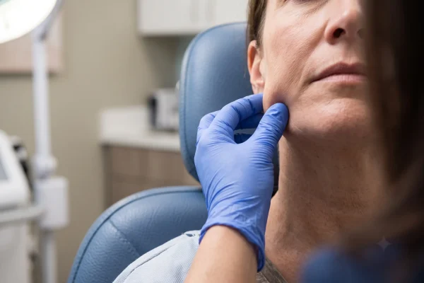 Provider checking facial skin to decide PDO thread candidacy