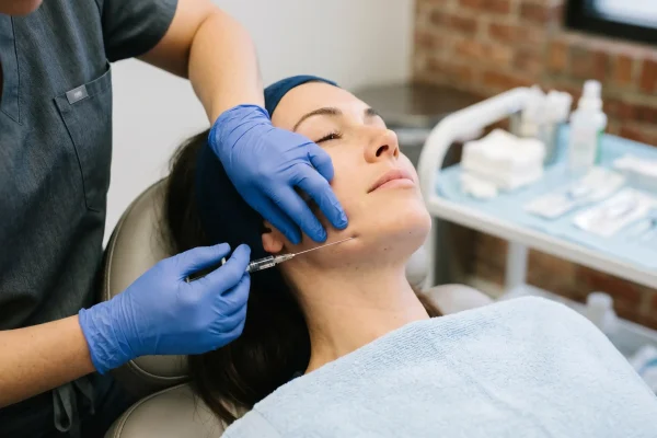 Provider placing jawline filler with a cannula during a treatment