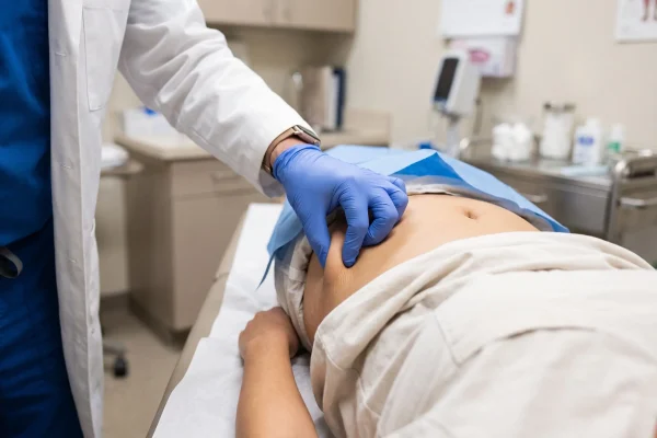 Skin elasticity pinch test during an HD liposuction candidacy check