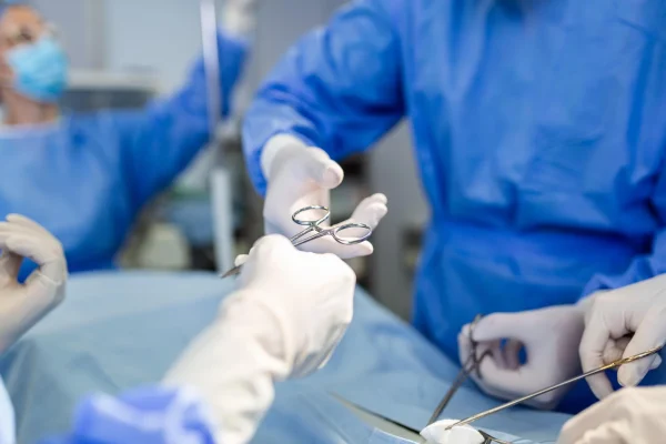 surgeon handing medical tool