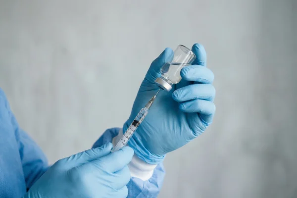surgeon holding a syringe and medical bottle