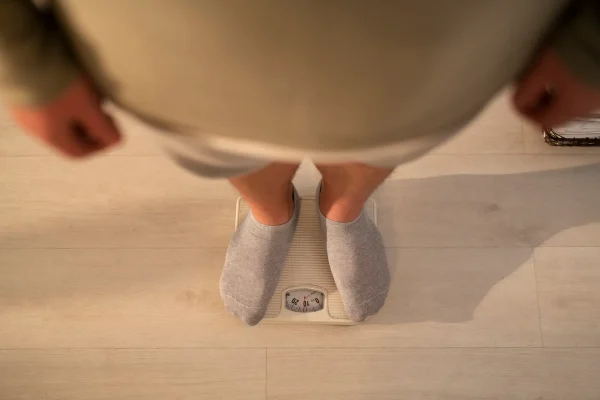 Top view plus-sized man standing on scale