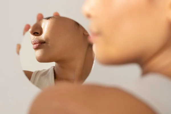 woman checking his face at the mirror