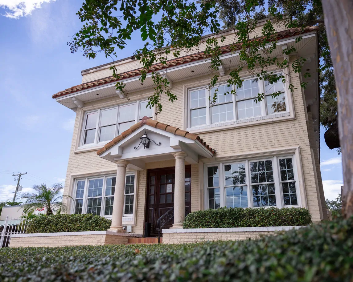 Two-story house with columns and garden