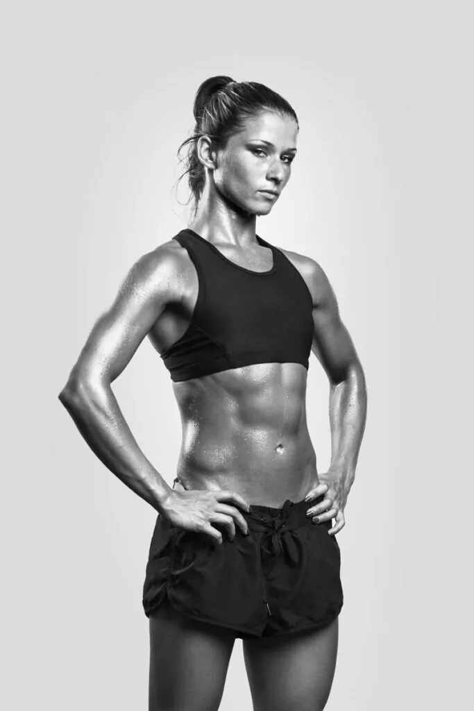 Athletic woman posing with hands on hips, abdominal muscles