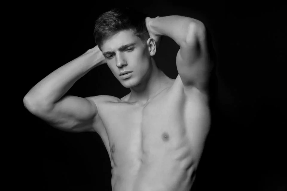 body sculpted male model, hands behind head after liposuction