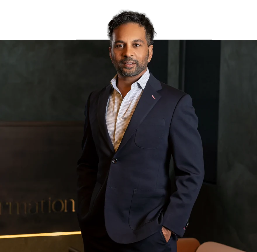 Dr. Gopal Grandhige posing inside the Formation Clinic in a dark suit.