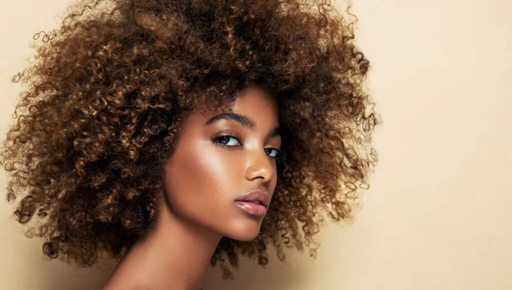 Woman with curly hair, neutral background