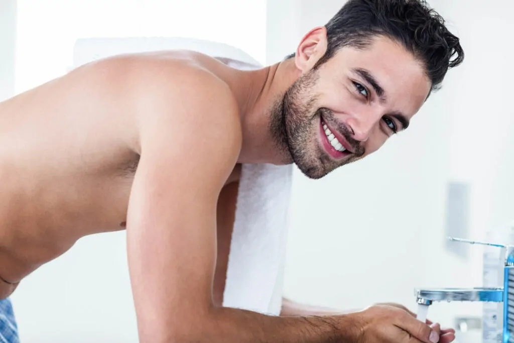 Smiling man flexing his handsome face after plastic surgery