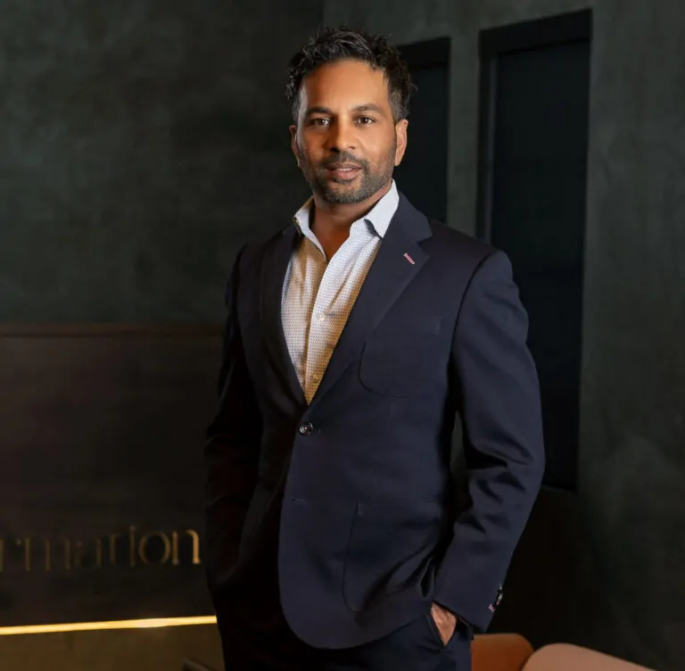 Dr. Gopal Grandhige posing inside the Formation Clinic in a dark suit.