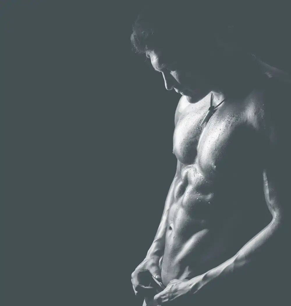 A man flexing his abs after plastic surgery