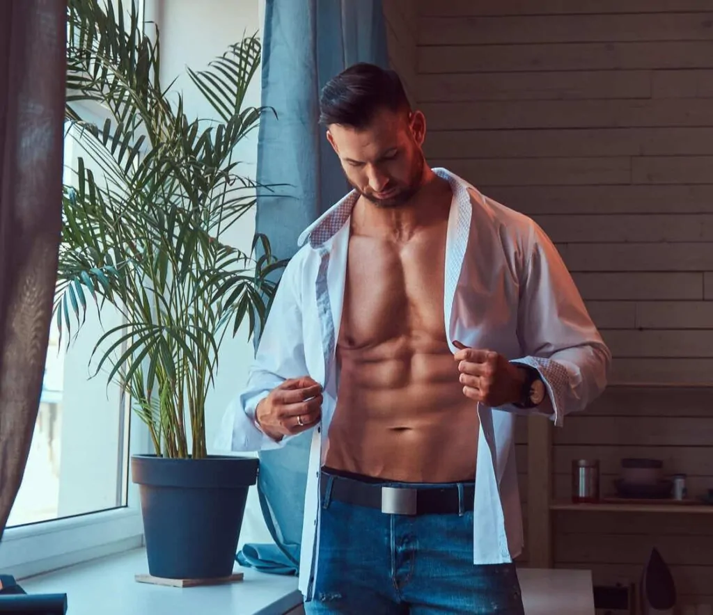 A handsome muscular male dresses a white shirt
