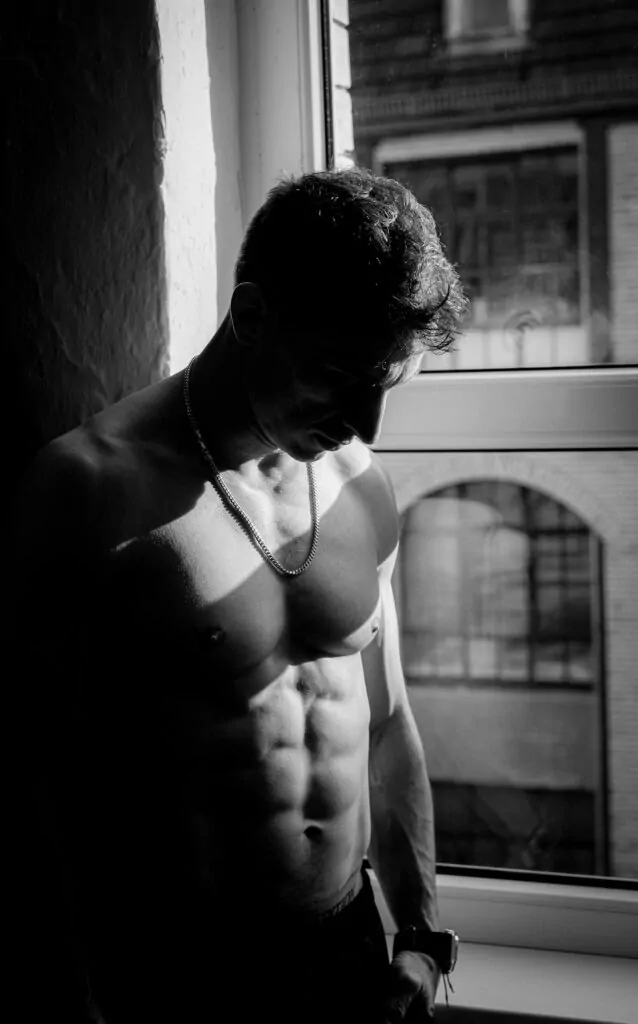 man looking at his sculpted abdomen after plastic surgery